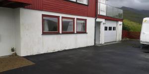 SelatraðLovely 1 BR condo with free parking on premises的车库,有红色和白色的建筑和一辆面包车