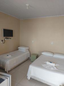 佩尼亚Hospedagem Quinta do Correia的酒店客房设有两张床和一台平面电视。