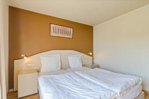 韦特伦布洛门拉旅馆的一间卧室配有一张带白色床单的大床
