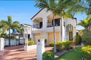 黄金海岸Large, Light, dog friendly home 600m to Burleigh beach的前面有棕榈树的房子