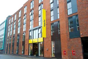 伯明翰Staycity Aparthotels Birmingham Jewellery Quarter的砖砌的建筑,上面有黄色的标志