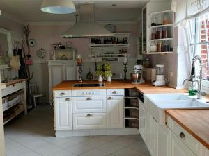 SurwoldLuana`s White Cottage的厨房配有白色橱柜和水槽