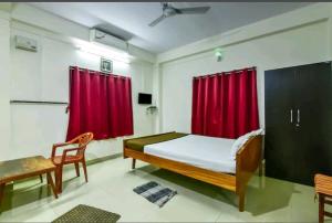 布莱尔港Andaman Castle的一间卧室配有床和红色窗帘