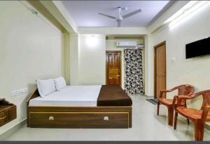 布莱尔港Andaman Castle的一间卧室配有一张床、两把椅子和电视