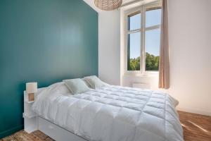 勒克鲁西克Bel appartement vue sur le port du Croisic的蓝色的卧室设有一张大床和一个窗户