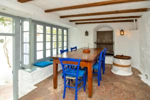 伊兹拉Hydra town, Relaxing patio Panoramic sea view的一间带木桌和蓝色椅子的用餐室