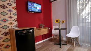 地拉那KONI's Studio Apartments的厨房配有小桌子和墙上的电视。