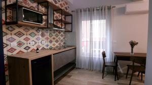 地拉那KONI's Studio Apartments的厨房配有书桌和带电视的桌子