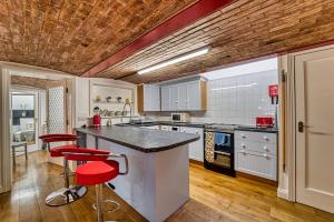 伍斯特Guest Homes - The Basement On The Tything的厨房里设有柜台和红色凳子