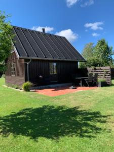 奥贝克Hytten的一个带黑色屋顶和野餐桌的谷仓