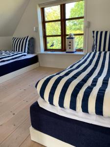 奥贝克Hytten的一间卧室配有两张蓝色和白色条纹的床