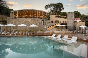 巴古尔TALAIA PLAZA ECORESORT BEGUR的一座带椅子的游泳池以及一座建筑