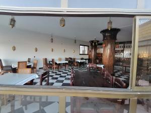 达哈布Dahab Bay hotel的一间带桌椅的用餐室和窗户。