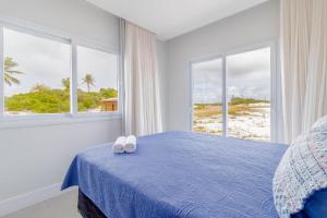 科斯塔萨乌佩SA06 Excelente Casa 5 Quartos - Reserva de Sauípe的一间卧室配有蓝色的床和2条白色毛巾