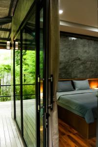 阁遥岛Annie Meen's place Koh Yao Noi的一间卧室设有一张床和一个滑动玻璃门