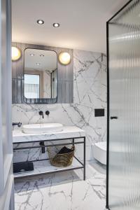 波雷奇Martis Forum Heritage Hotel & Residence的大理石浴室配有水槽和镜子