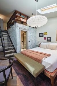 波雷奇Martis Forum Heritage Hotel & Residence的一间带大床和楼梯的卧室