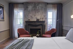 波雷奇Martis Forum Heritage Hotel & Residence的一间卧室配有一张床、两把椅子和一个壁炉