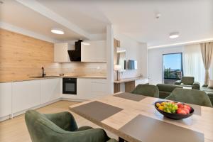 普罗马尼亚Aparthotel Remaneo的厨房以及带桌椅的用餐室。