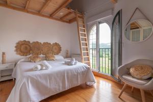 Puente ArceFidalsa Majestic的一间卧室配有一张床、一把椅子和一个大窗户