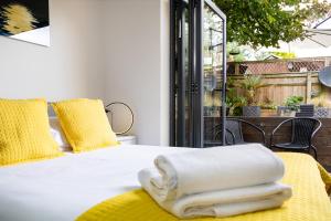 BucknellVillage Retreat & Hot Tub Nr Bicester Village的一间卧室配有白色床和黄色枕头
