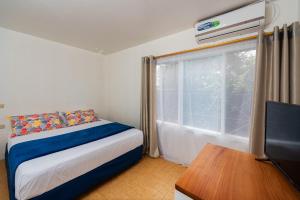阿约拉港Hostal North Seymour的一间卧室设有一张床、一台电视和一个窗口。