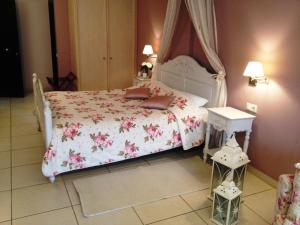 纳夫普利翁艾林农宾馆的卧室配有白色的粉红色花床