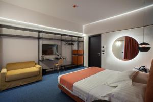 马泰拉Hotel Dimora Del Monaco的一间卧室配有一张床、一把椅子和电视