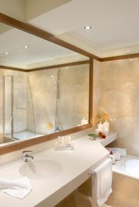 沃洛斯沃洛斯宫殿酒店的浴室配有水槽、淋浴和浴缸。