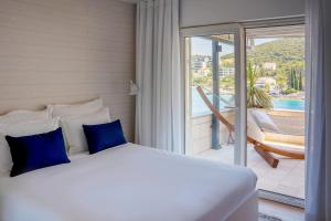 科尔丘拉塔拉旅馆酒店的带阳台的客房内一张带蓝色枕头的床