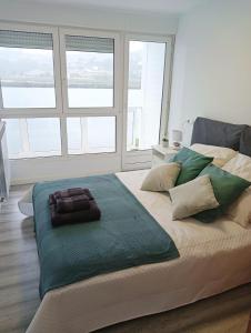 纳维亚Apartamento Ría Navia的白色的客房设有大窗户,配有一张大床。