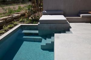 奥马斯帕纳吉亚斯Pure Villas的庭院里的一个蓝色海水游泳池