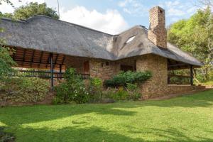 雾观Kruger Park Lodge Unit No. 547的一座带茅草屋顶的老砖屋