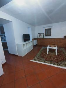 卡普拉罗拉La Casetta的客厅配有电视和桌子