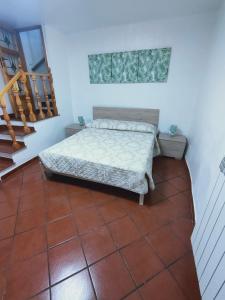 卡普拉罗拉La Casetta的卧室配有1张床,铺有瓷砖地板。