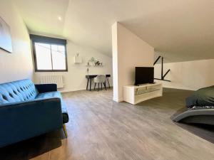 勒芒Residence Belfort的客厅配有蓝色的沙发和电视