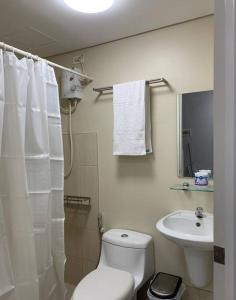 马尼拉Cozy 1 Bedroom near Alabang Town Center and Molito with Wifi and Netflix的白色的浴室设有卫生间和水槽。