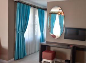 王子岛群Noya Köşk Otel的一间设有蓝色窗帘和镜子的客房