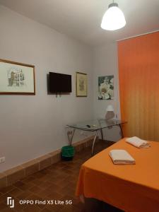 AragonaZAHRA ARAGONA的一间设有桌子和墙上电视的房间