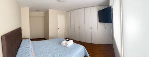 利马2110 Miraflores - Luxury Room in the Best Place的一间卧室配有蓝色的床和白色橱柜