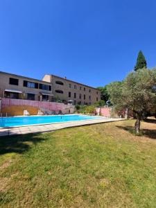 ViensLogement d'exception près du Colorado provencal dans une résidence au calme avec piscine offrant une vue imprenable sur le Luberon depuis sa terrasse的大楼前的游泳池