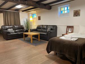 卡尔斯港Port Hotel Apartments的一间卧室配有皮革家具、一张床和一张桌子