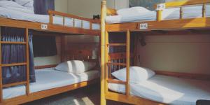 台南东宁文旅的客房内的2张双层床和白色枕头