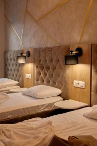 普里什蒂纳Amico Hotel的灯火通明的房间的一排床位