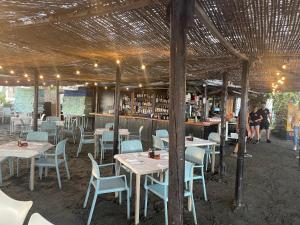 卡莱塔德贝莱斯La Casita del Pescador的一间带桌椅的餐厅和一间酒吧