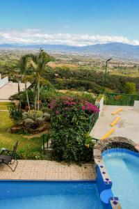 阿拉胡埃拉Loma Tranquila的享有房屋景致的游泳池