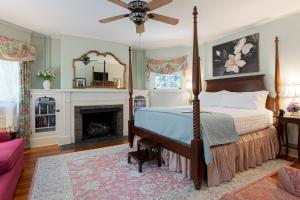 阿什维尔Pinecrest Bed & Breakfast的一间卧室设有一张天蓬床和一个壁炉