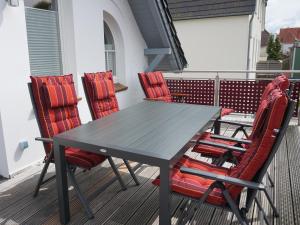 石勒苏益格Villa Ostgardie的阳台配有一张桌子和四把椅子