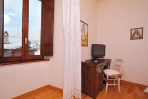 佩斯科克斯坦佐Hotel Le Torri的客房设有书桌、电视和窗户。