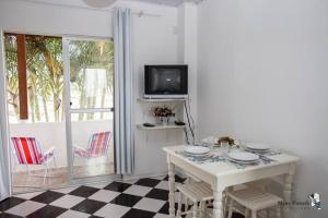 邦比尼亚斯Residencial di Raffaele em Bombinhas的一间白色的饭厅,配有桌子和电视
